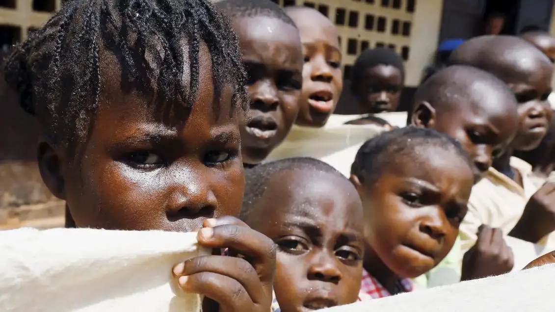 African kids in white shirts, looking in the camera