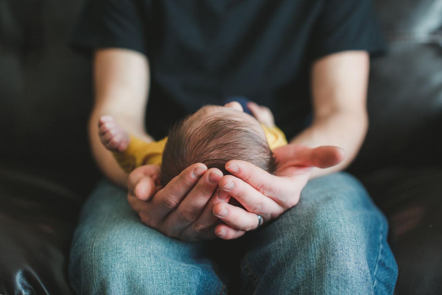 A man holding a baby in his hand