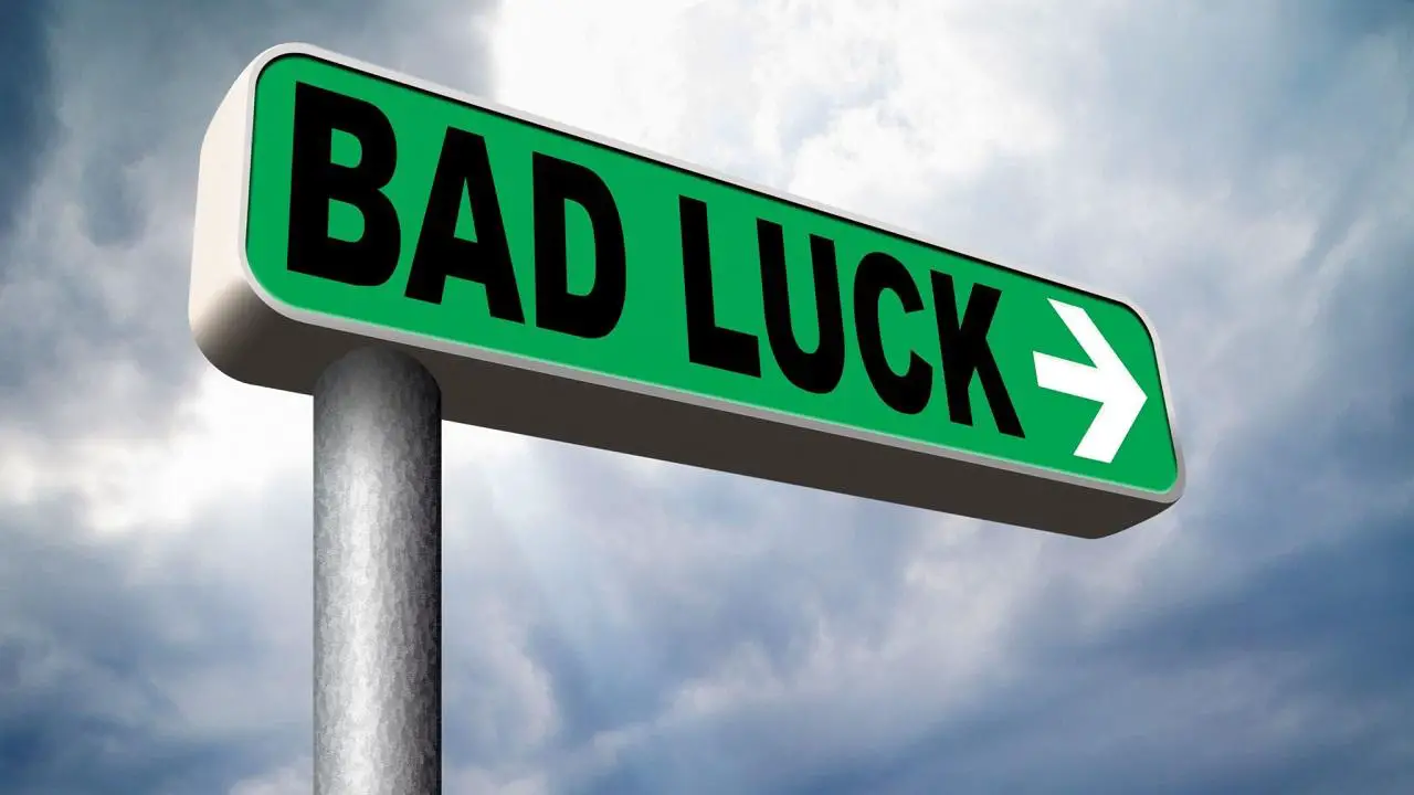 A Sign board of bad luck against the sky