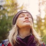 A girl breathing without any difficulty outside in a sunny day in a park