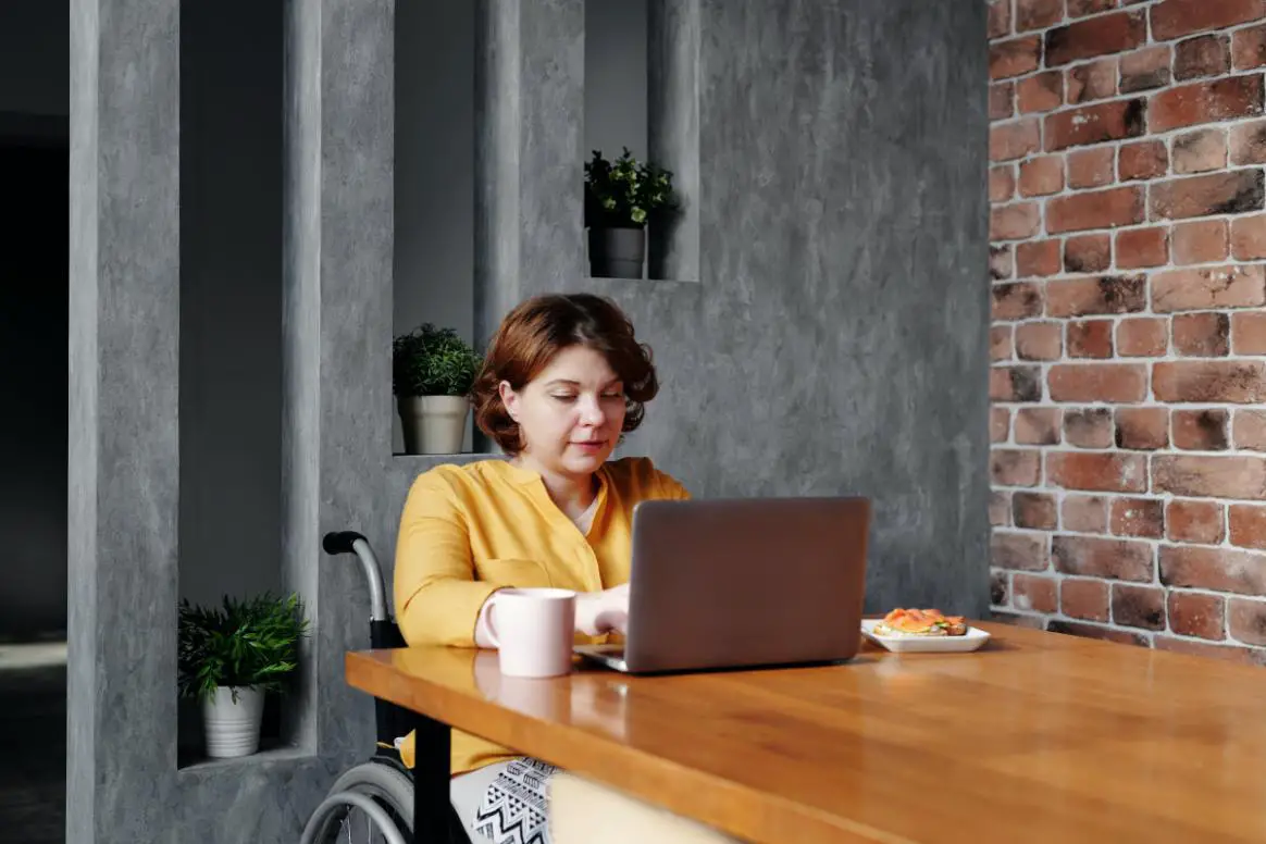 A Girl on a Wheelchair Working on her laptop from her Home