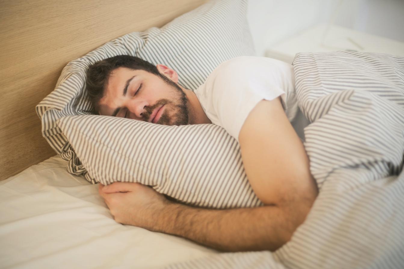 A man sleeping in his bed in a relaxing manner