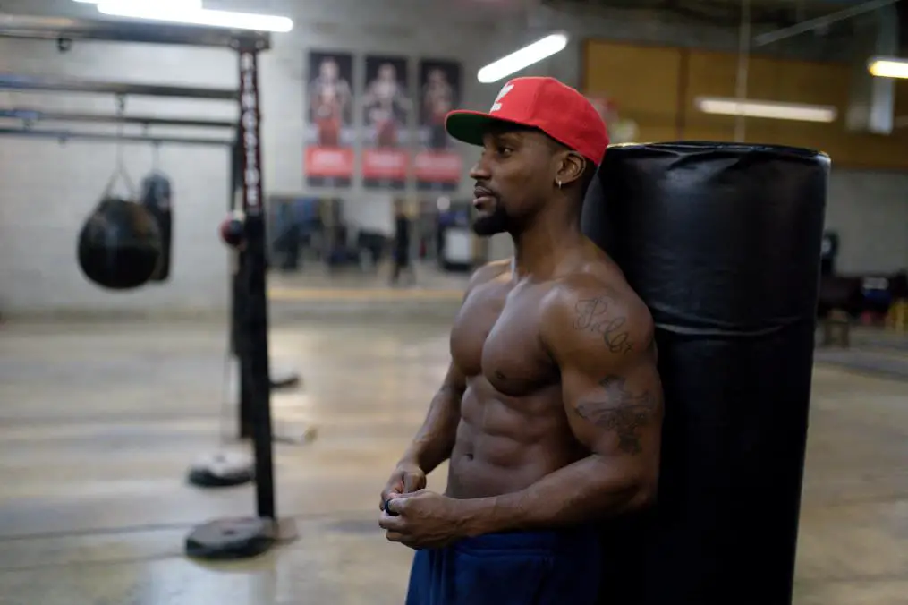 A person in his Gym showing off his developed body with confidence