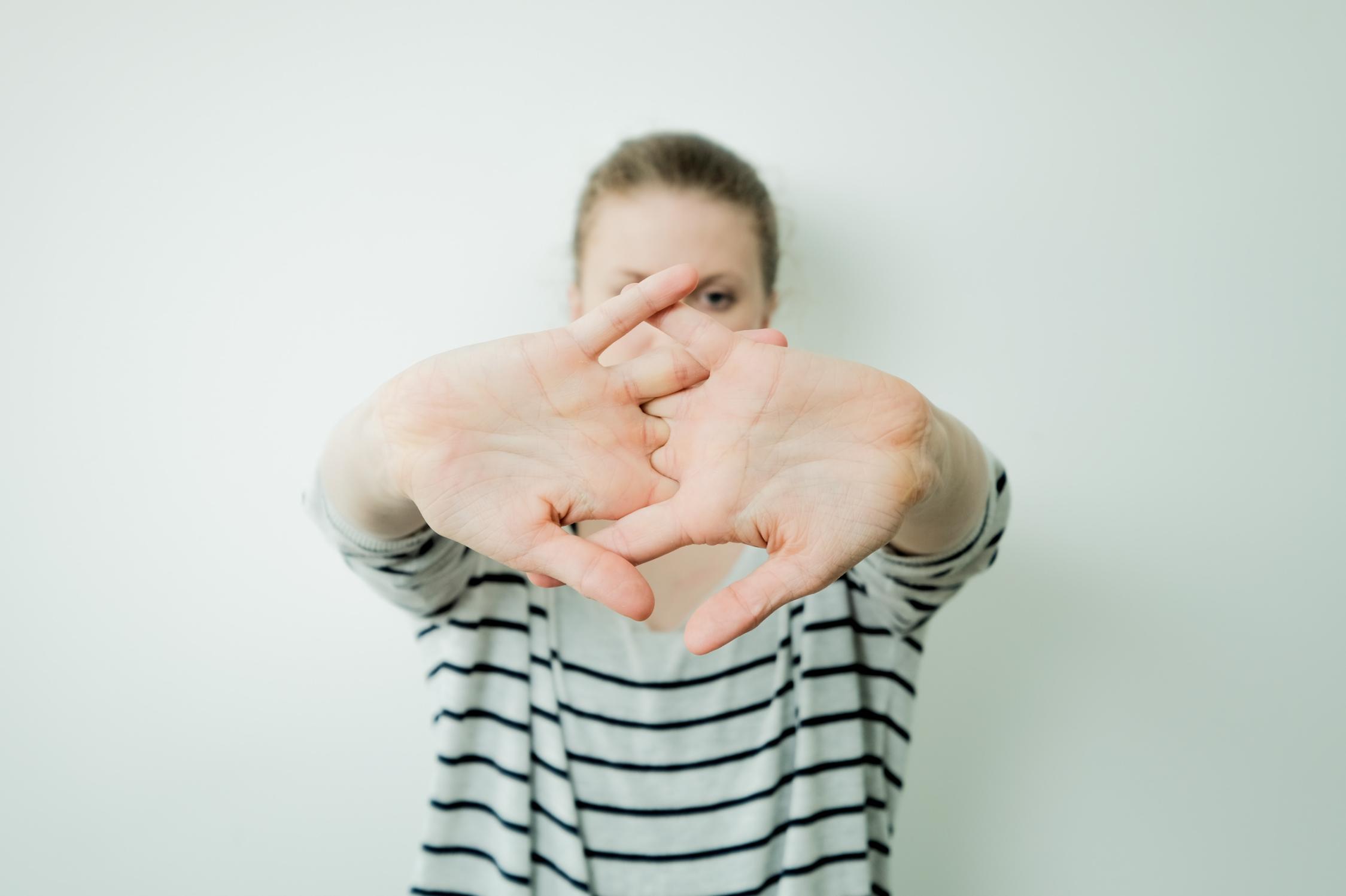 A Girl wearing a shirt cracking his knuckles
