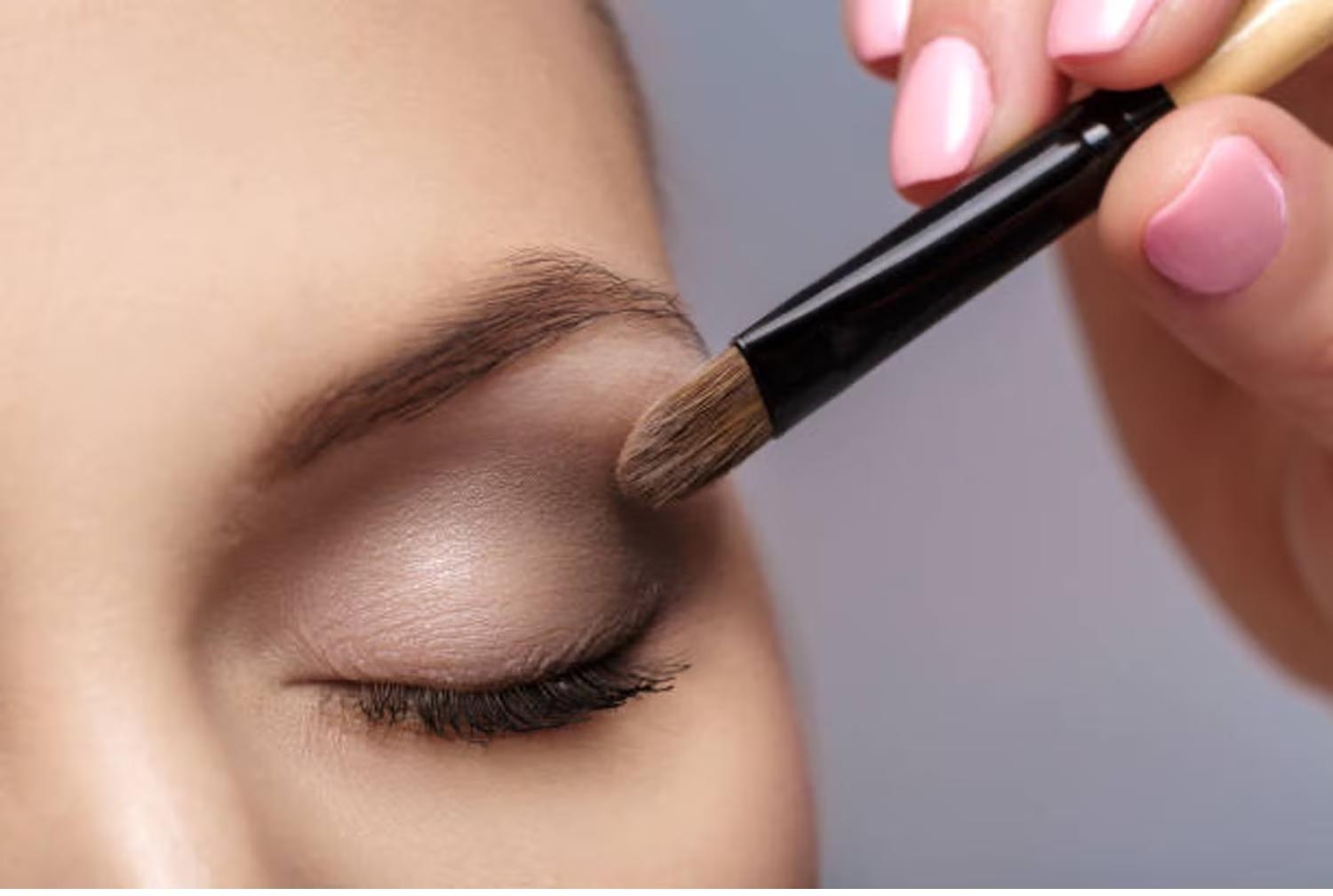A female HANd is Applying Eye Shade on A female face