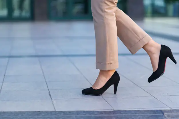 A woman's feet walking confidently in black heels