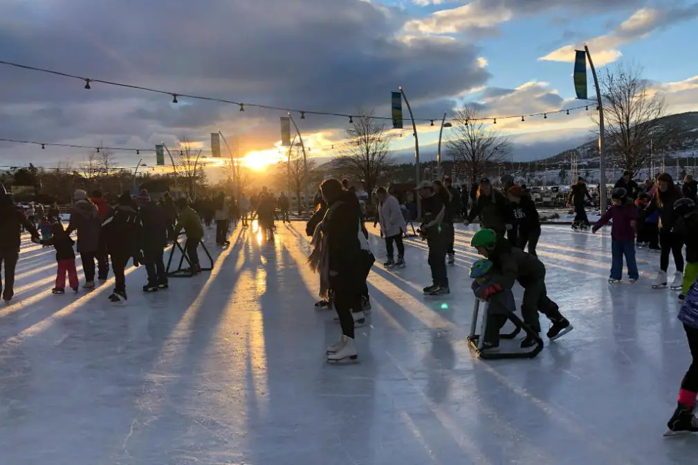Individuals enjoying ice skating against the backdrop of a beautiful sunset