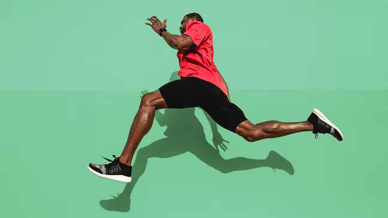 A runner in red shirt running very fast against green background
