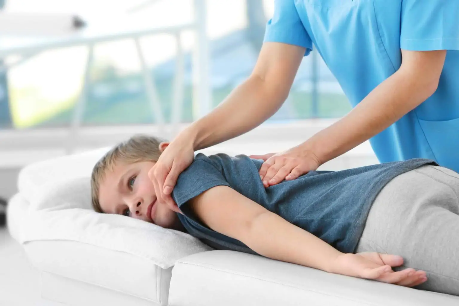 A chiropractor performing spinal on a kid