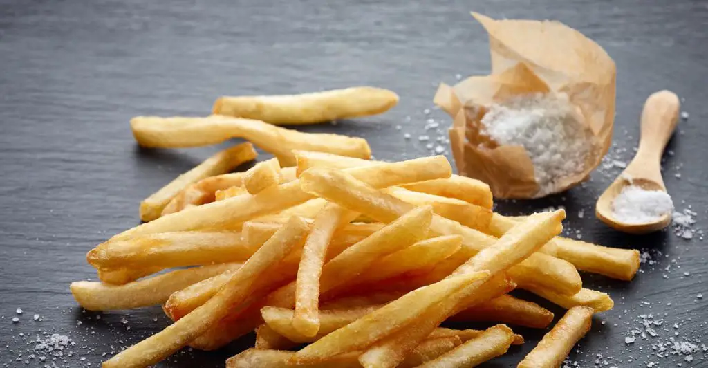 French Fries placed along side some table salt
