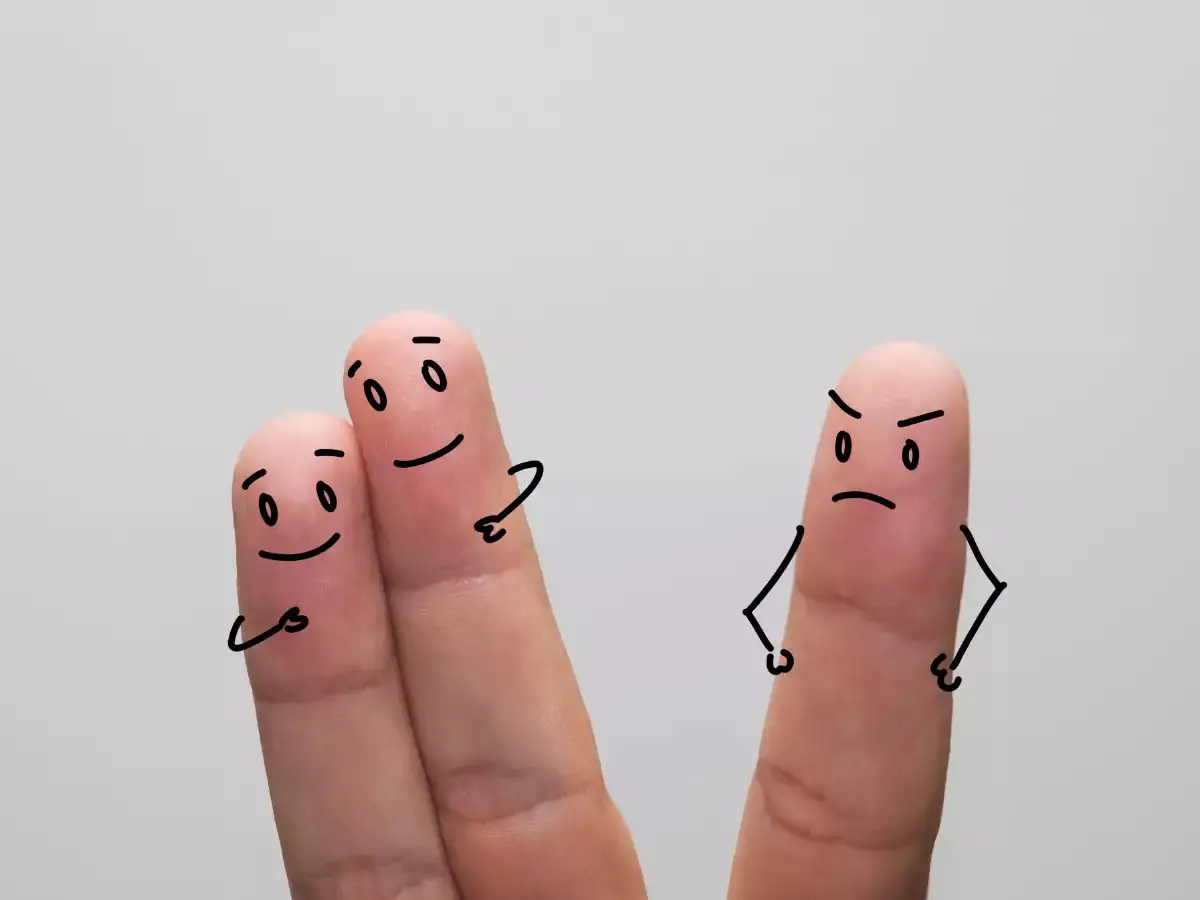 Three finger puppets: two close together, expressing love, while the third one, standing apart, showing jealousy and anger