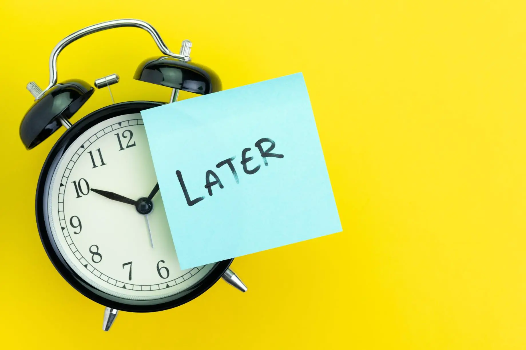 A clock, against yellow background, with a page attached to it on which later is written