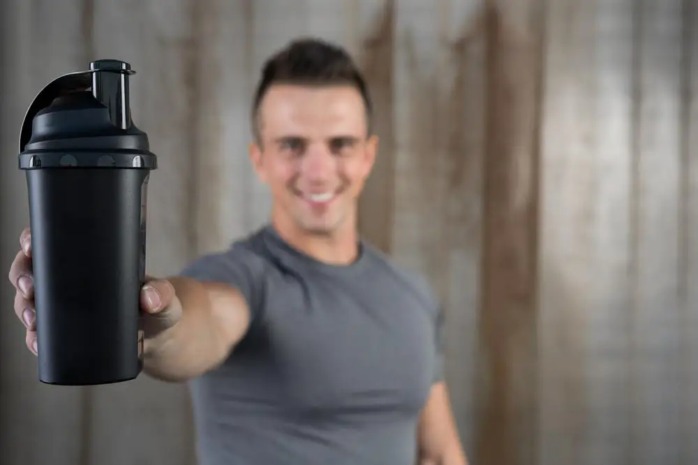 A man showing protein shake bottle