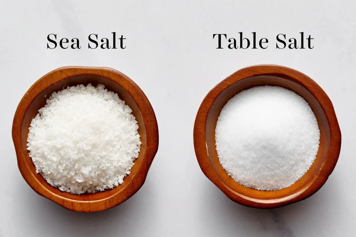 two bowls filled with salts namely sea salt and table salt