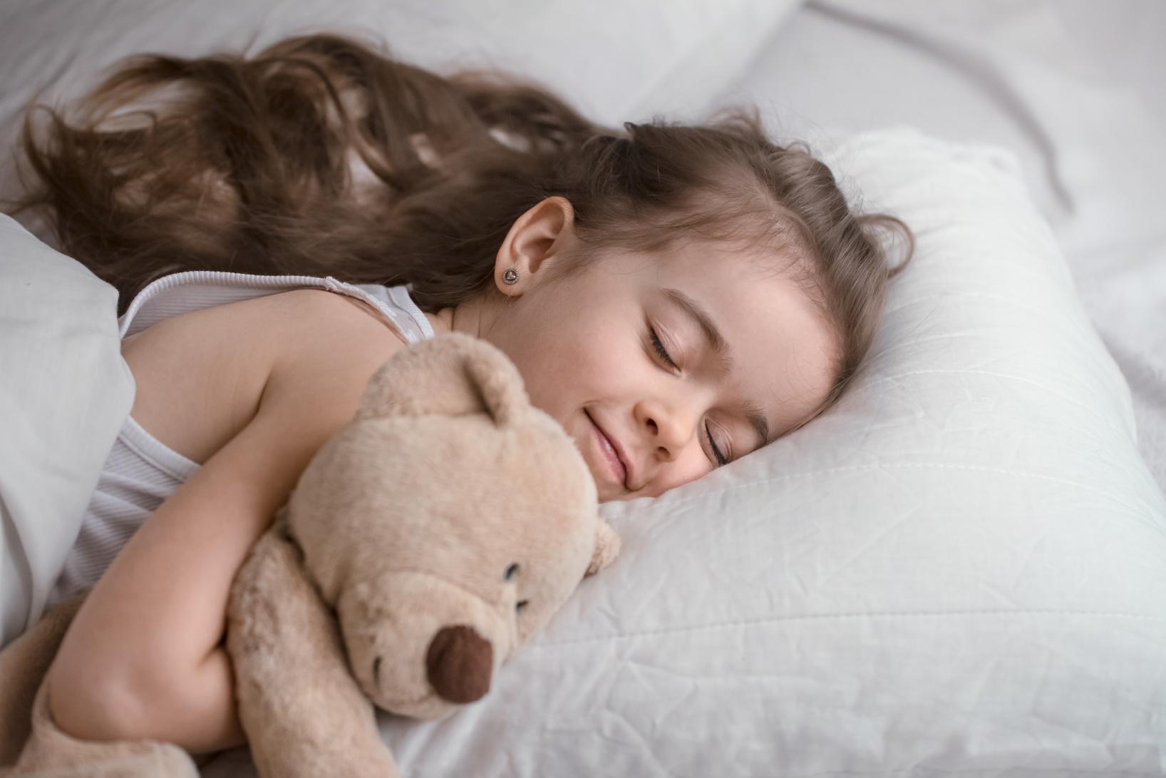A little girl holding her toy sleeping comfortable