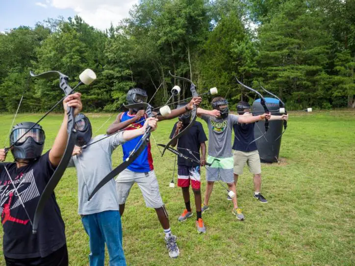 A group of six individuals taking aim at a target while engaging in Archery Tag.
