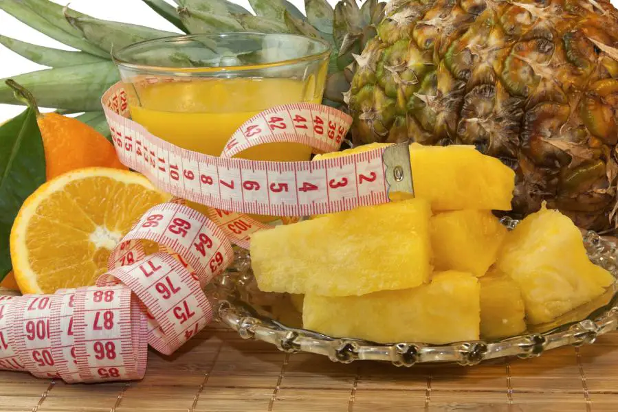 Fruits arranged with a measuring tape, symbolizing weight management through the incorporation of fruits into the diet..