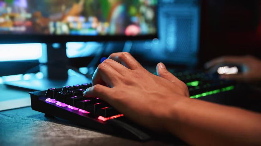 A male hand pressing a mechanical keyboard