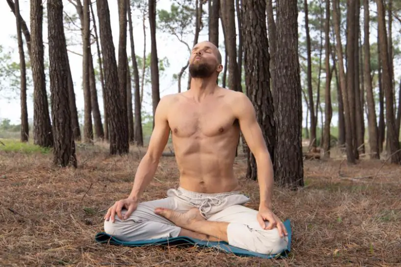 A man doing yoga in jungle