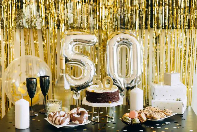 Birthday setup for someone who reached 50, featuring a cake, balloons, cookies, and other birthday decorations.