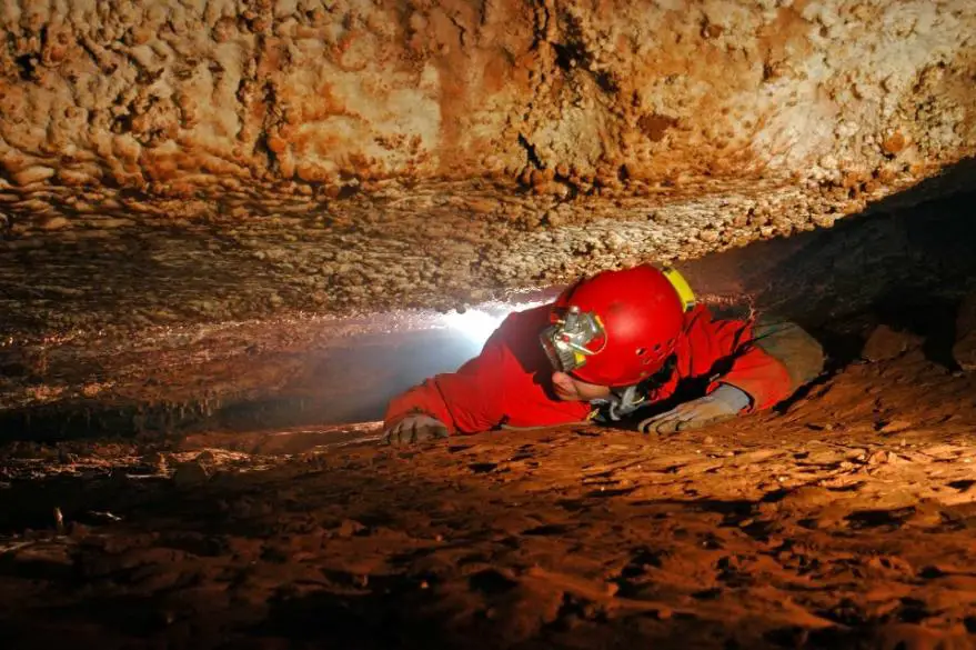 A girl navigating her way in a cave.