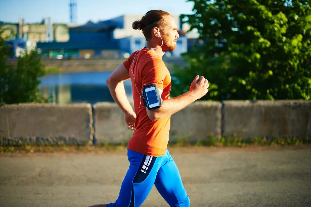 Healthy Man Doing Interval Running with Cell Phone Tied to Arm