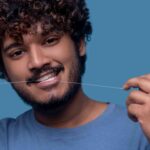 Man is flossing his teeth