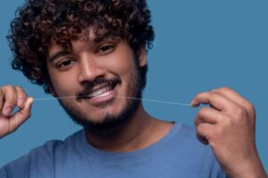 Man is flossing his teeth