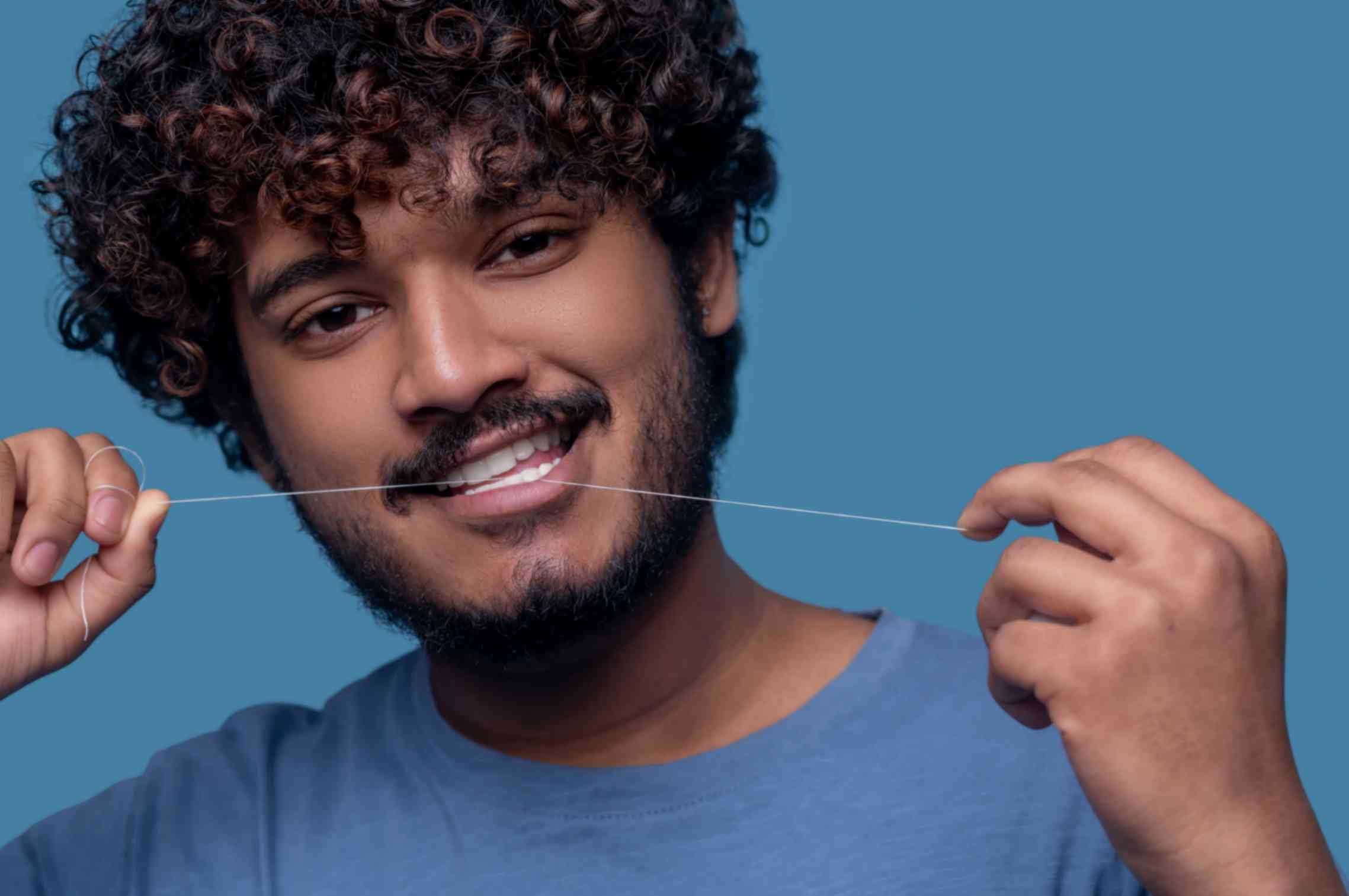 Man is flossing his teeth 