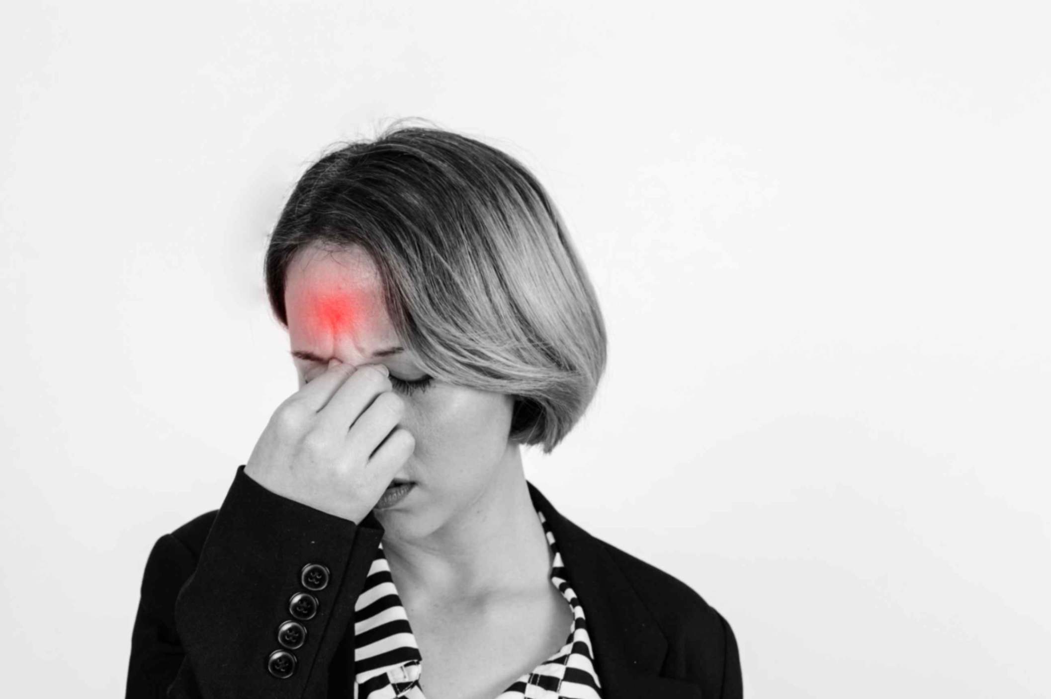 Woman suffering with migraine headache holding her nose