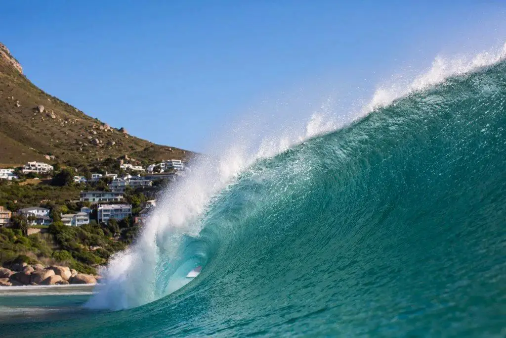 A huge wave on the side of a mountain with many houses