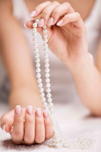 Women Holding Beautiful White Pearl Necklace