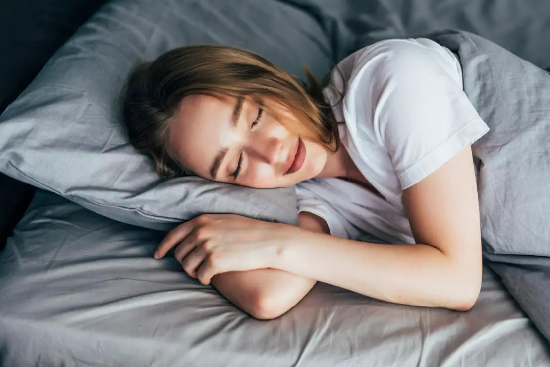 A Woman sleeping relaxed in her bed