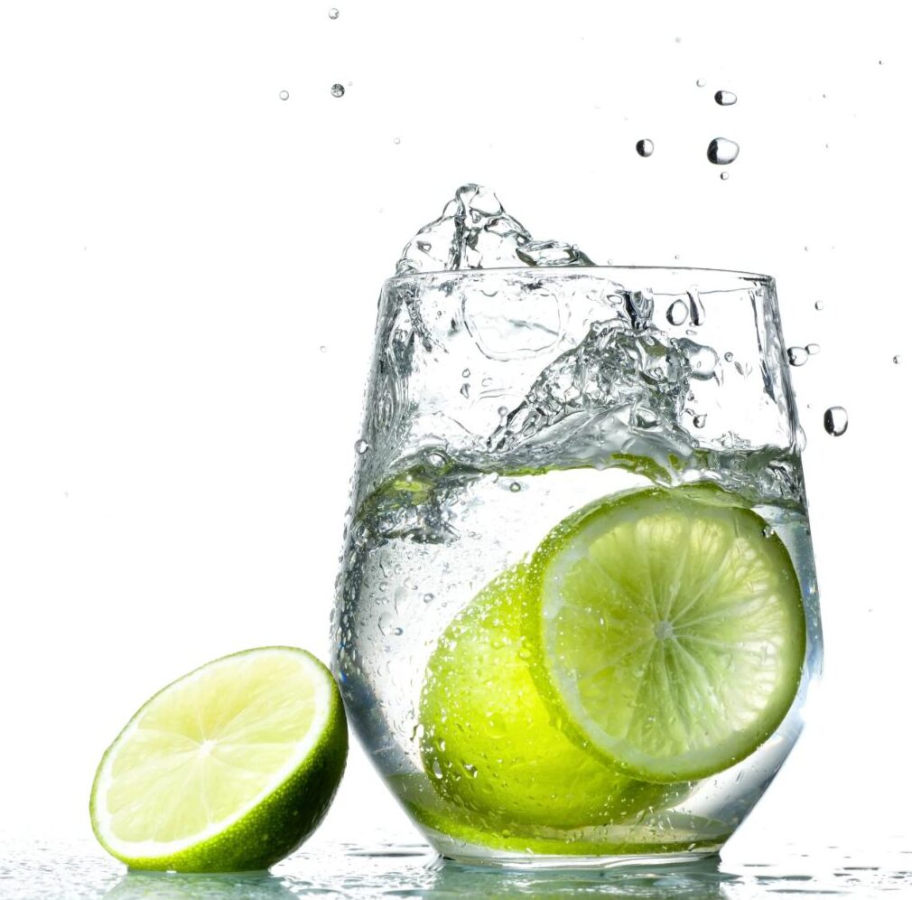 Lime juice in a glass with splashes suspended in the air..
