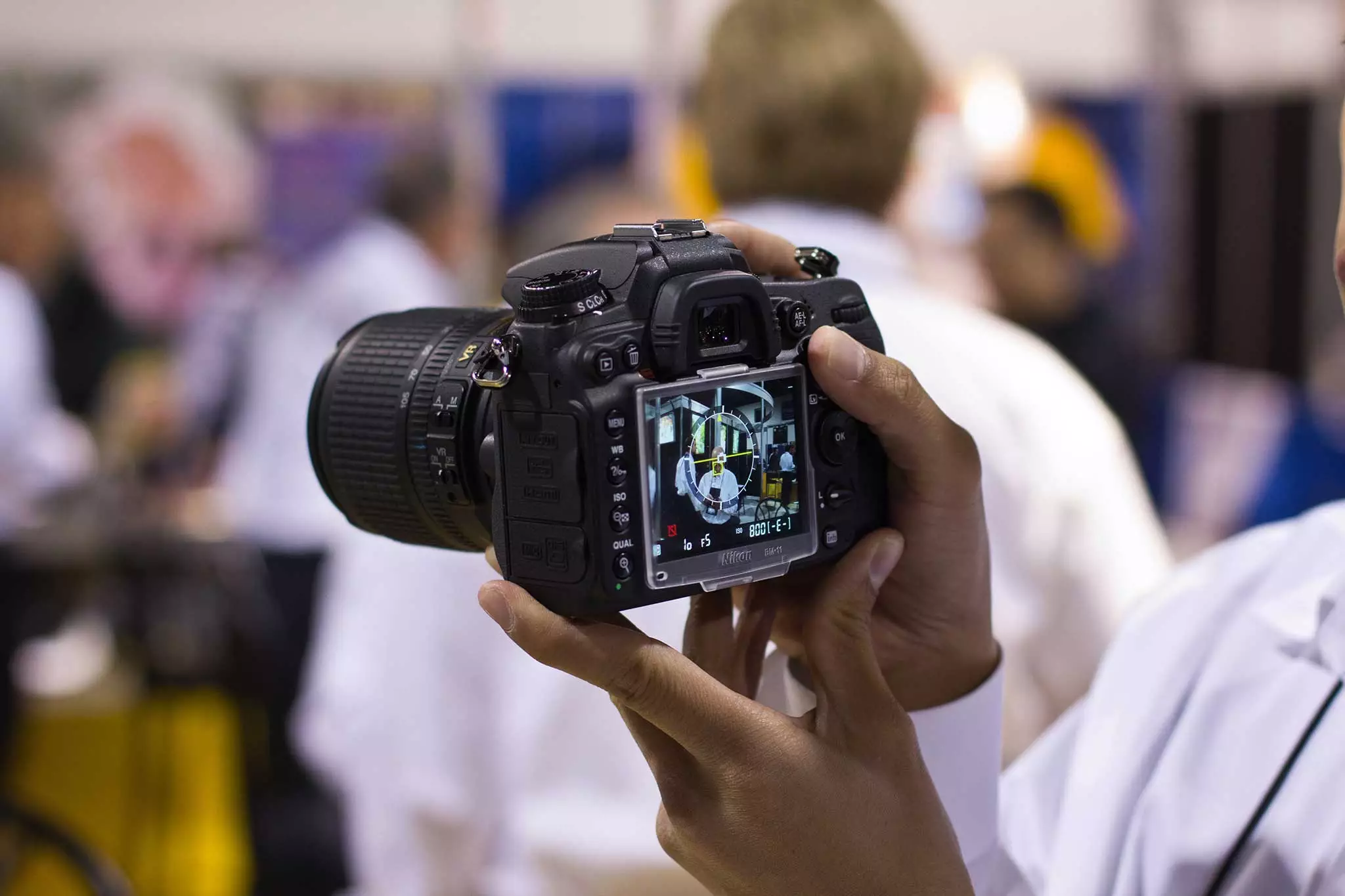 A person capturing a picture against a blurred background,
