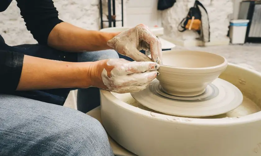 Close-up of a person's hands engaged in pottery,