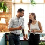 A couple talking to each other standing in the kitchen