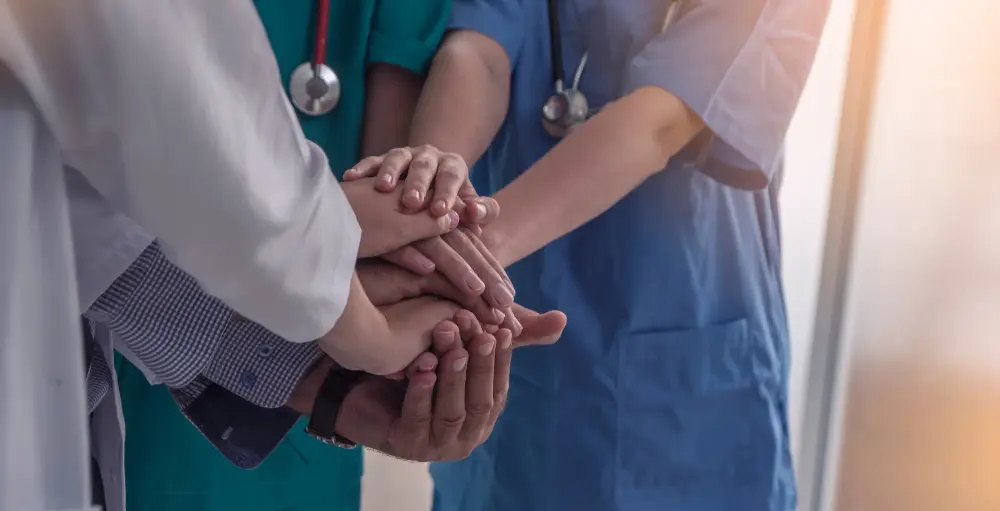 Nurses and doctors joined hands in unity, symbolizing collaboration and teamwork.