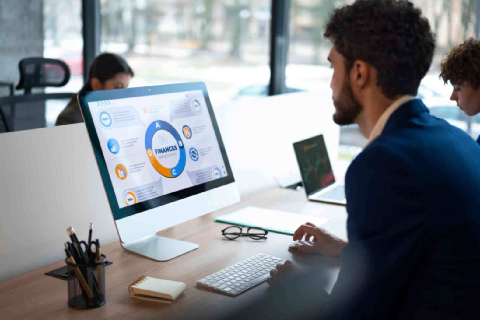 A man in the office analyzing and checking finance graphs on desktop computer