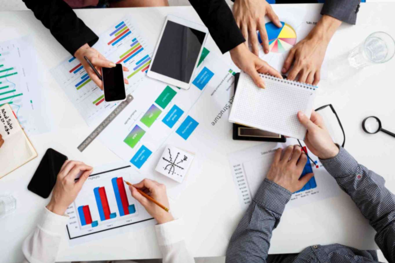 Picture shows Businessmen hands on white table with documents and drafts