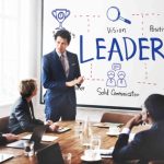 Boss highlighting the importance of change management to his employees in presentation room