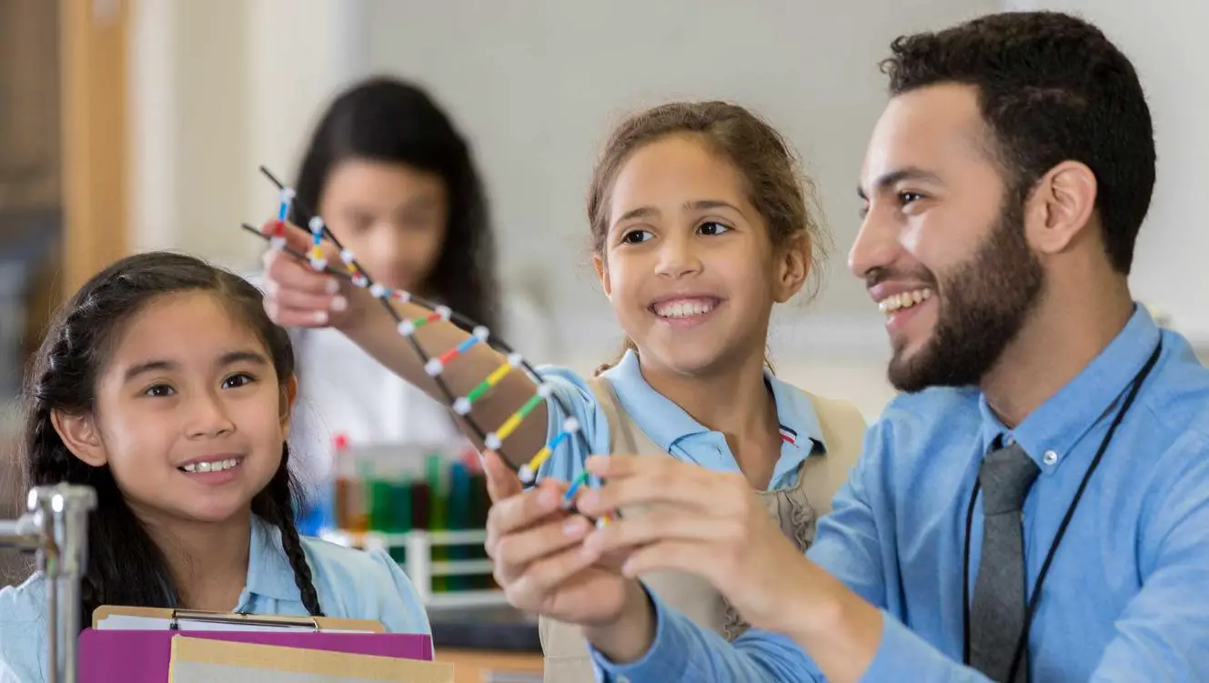 An Cheerful Male Teacher Demonstrating a DNA Model to His Students