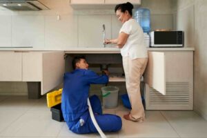 Plumber Fixing Kitchen Pipe