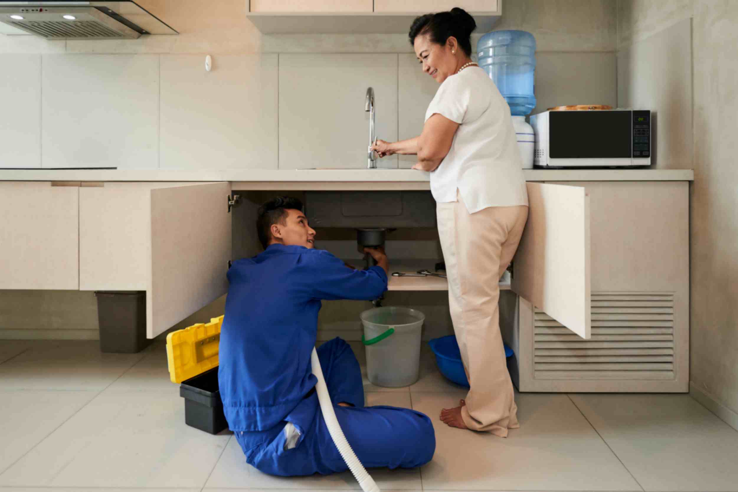 Plumber Fixing Kitchen Pipe