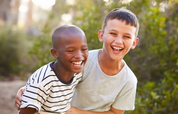 Two boys laughing heartily together.