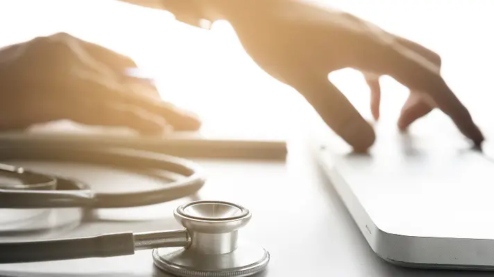 Selective focus Stethoscope and Doctor working an tablet on desk in hospital