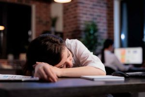 Tired Women From Work Sleeping on Desk