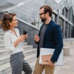 man and woman talking while standing in urban city center