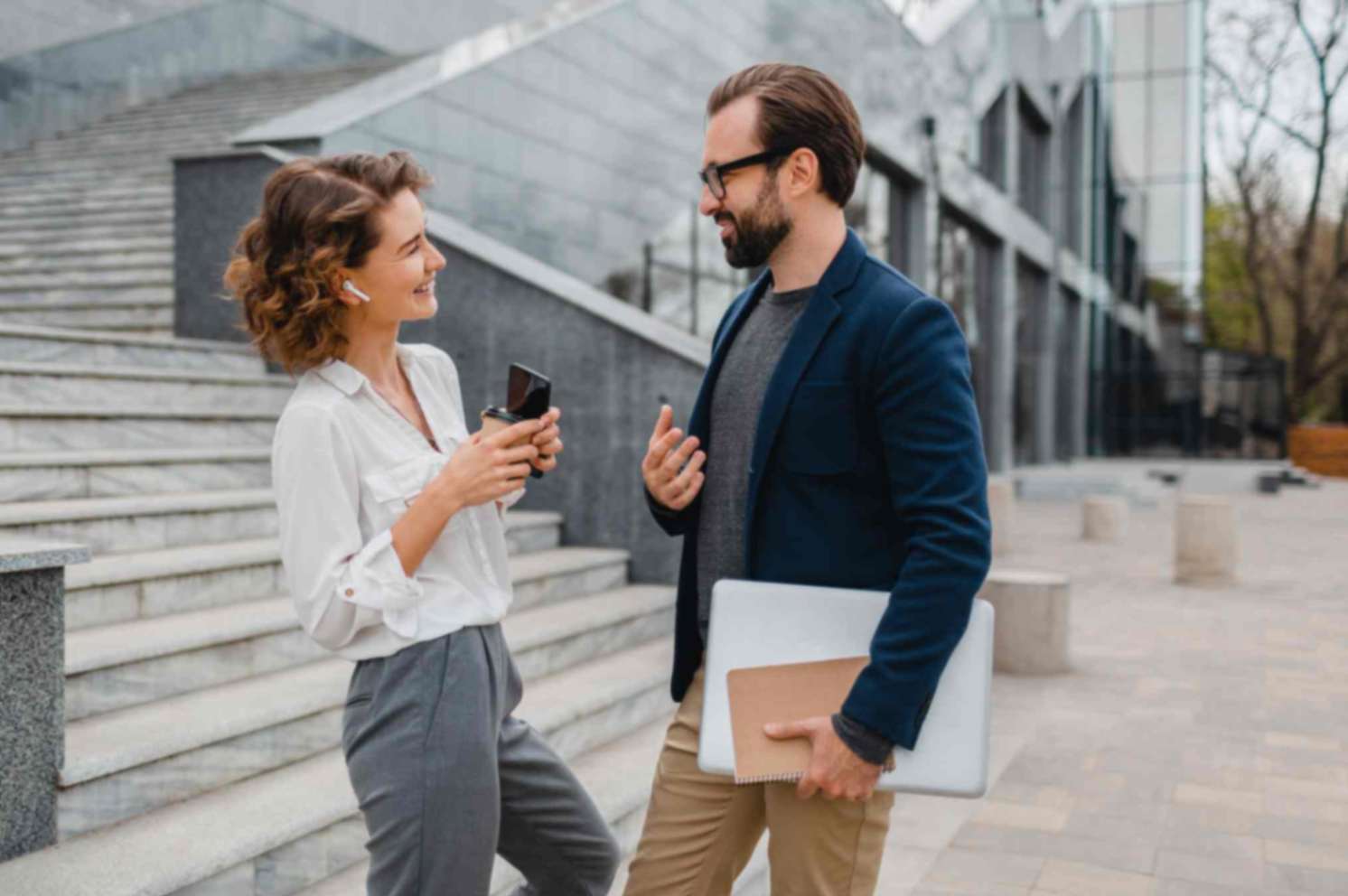  man and woman talking while standing in urban city center