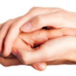 Picture of hands of two people stacked over each other